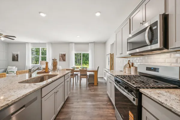 a kitchen with stove a sink and chairs