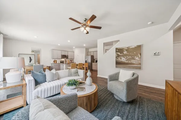 a living room with furniture and a view of kitchen