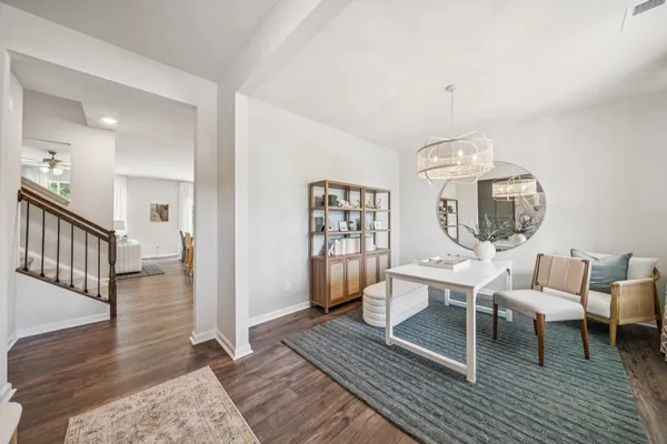 a living room with furniture a wooden floor and next to a window