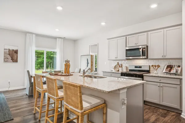 a kitchen with granite countertop white cabinets and stainless steel appliances