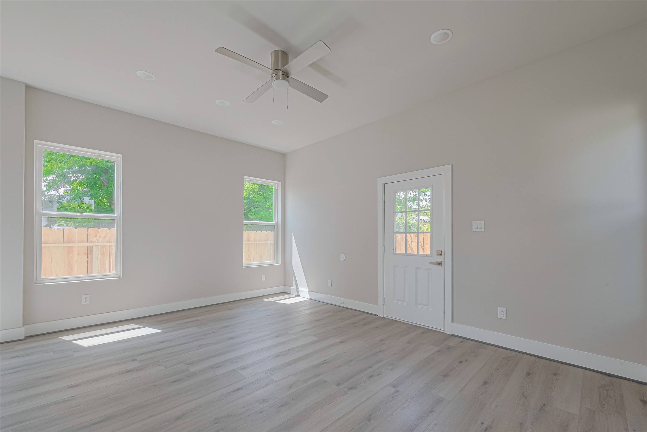 7207 Force Street Houston, TX 77020 - Photo 4 of 29 The living room features a ceiling fan to add comfort, and a door leads to an outdoor area.