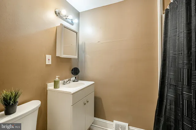a bathroom with a sink a toilet and a mirror