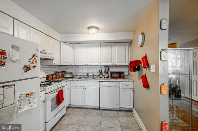 a kitchen with white cabinets and white appliances