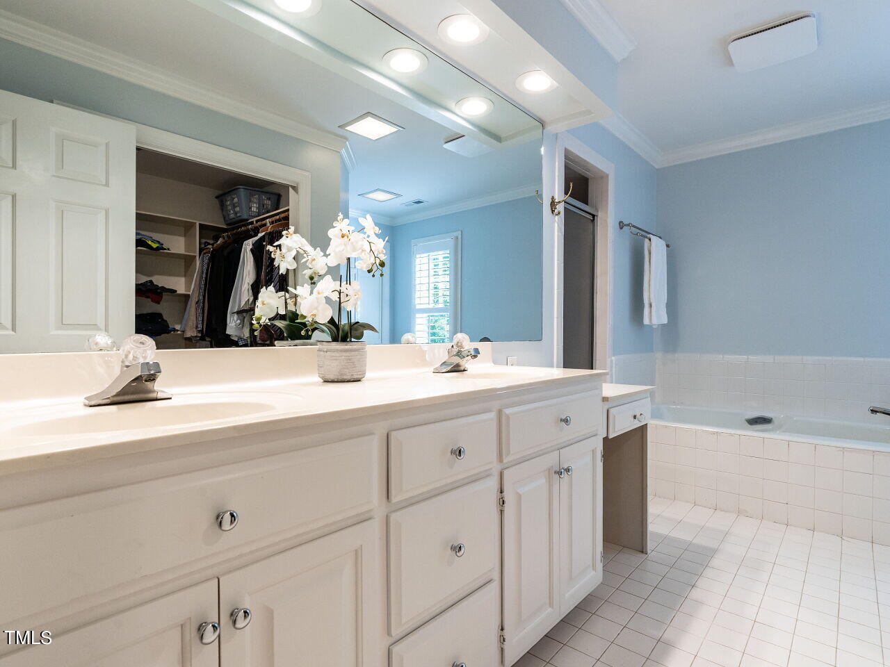 2100 Fallon Oaks Court Raleigh, NC 27608 - Photo 11 of 20 a bathroom with double vanity sinks a vanity a lamp and a bathtub