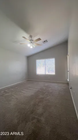 an empty room with a window and a ceiling fan