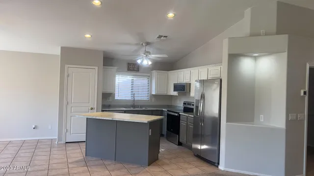 a kitchen with stainless steel appliances granite countertop a refrigerator and a sink
