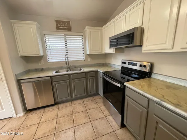a kitchen with stainless steel appliances granite countertop a sink stove top oven and microwave