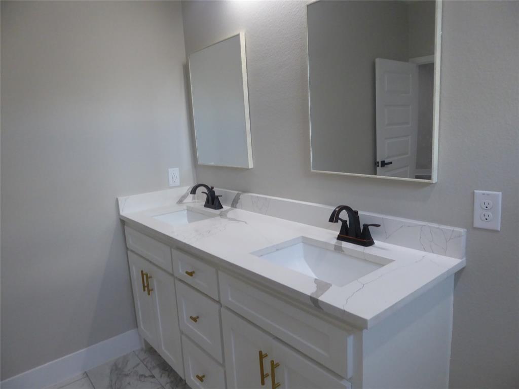 230 Third Street Wilmer, TX 75172 - Photo 13 of 40 a bathroom with a sink and a mirror