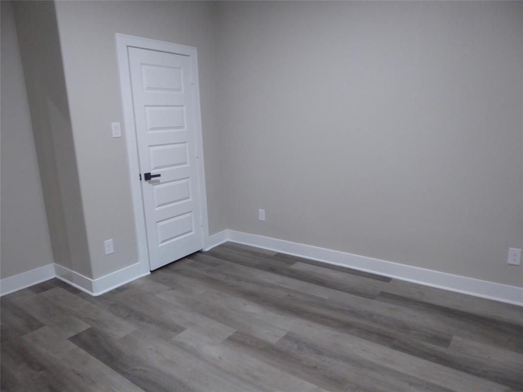 230 Third Street Wilmer, TX 75172 - Photo 21 of 40 an empty room with wooden floor