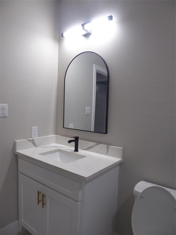 230 Third Street Wilmer, TX 75172 - Photo 39 of 40 a bathroom with a sink and a toilet
