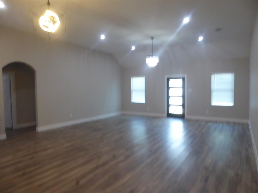 230 Third Street Wilmer, TX 75172 - Photo 7 of 40 an empty room with wooden floor and windows
