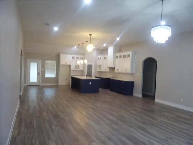 a view of kitchen and hall with wooden floor and windows