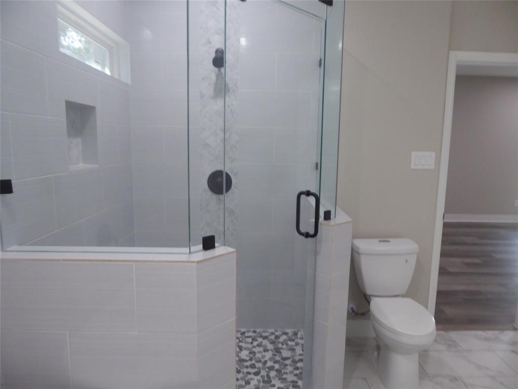 230 Third Street Wilmer, TX 75172 - Photo 10 of 40 a bathroom with a toilet and shower