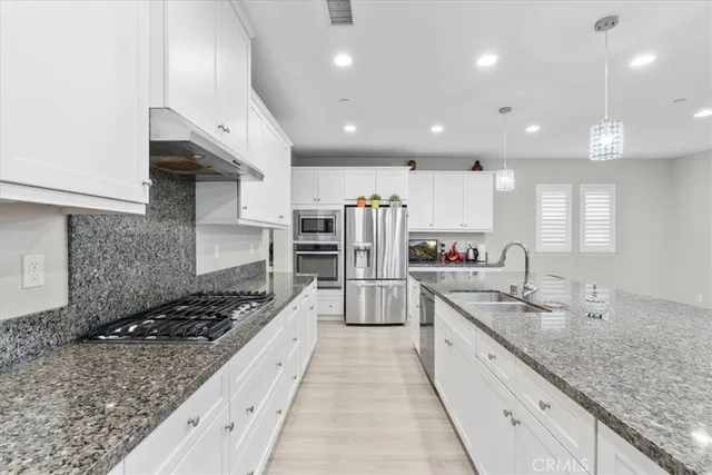 a large kitchen with stainless steel appliances kitchen island granite countertop a large stove top oven and cabinets