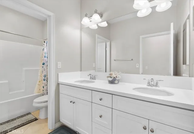 a bathroom with a double vanity sink mirror and toilet