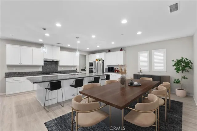 a kitchen with a dining table chairs stove a sink and dishwasher