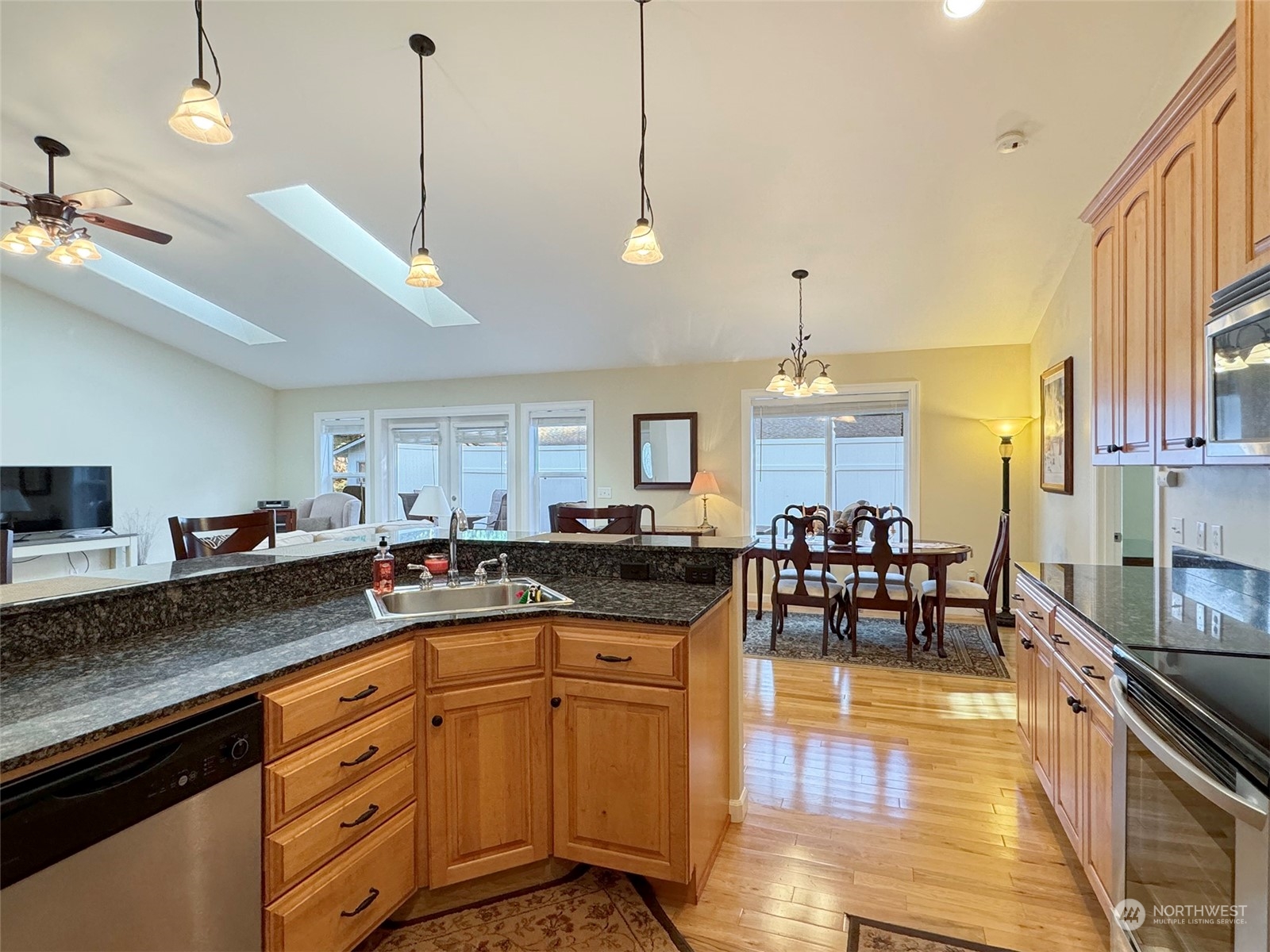 359 Dungeness Meadows Sequim, WA 98382 - Photo 10 of 37 a kitchen with stainless steel appliances granite countertop a stove a refrigerator a sink dishwasher a dining table and chairs with wooden floor
