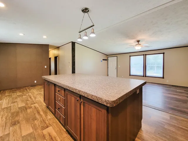 a kitchen with kitchen island a sink wooden floor and a large window