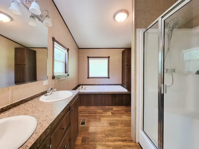 a bathroom with a granite countertop sink a mirror and a shower