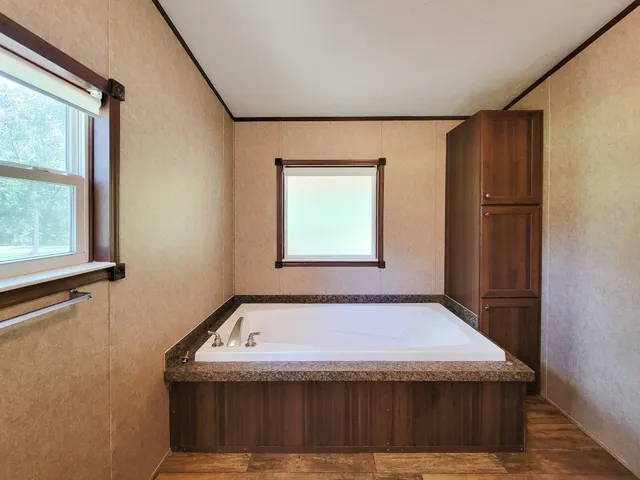 a view of a bedroom with wooden floor and windows
