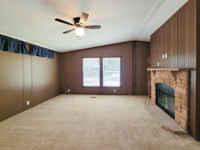 an empty room with windows and fireplace