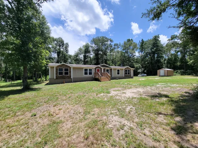 a view of a house with backyard and a tree