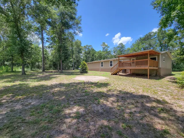 a view of a house with a yard and sitting area