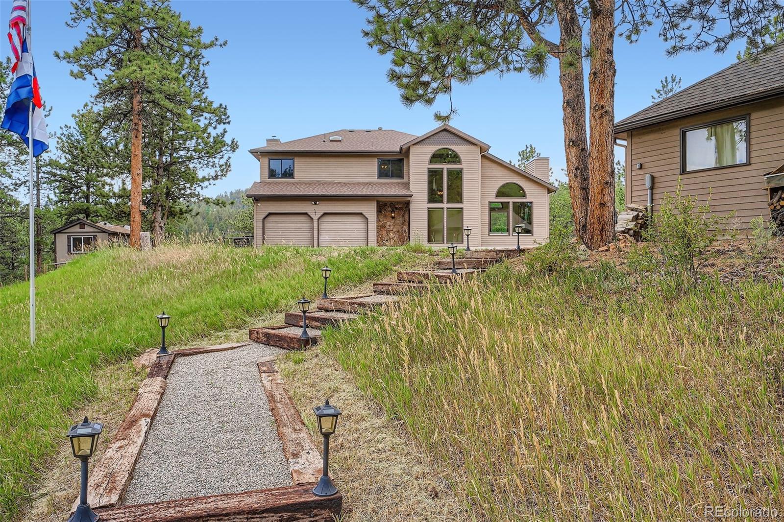 13342 Douglass Ranch Drive Pine, CO 80470 - Photo 3 of 31 a front view of a house with garden