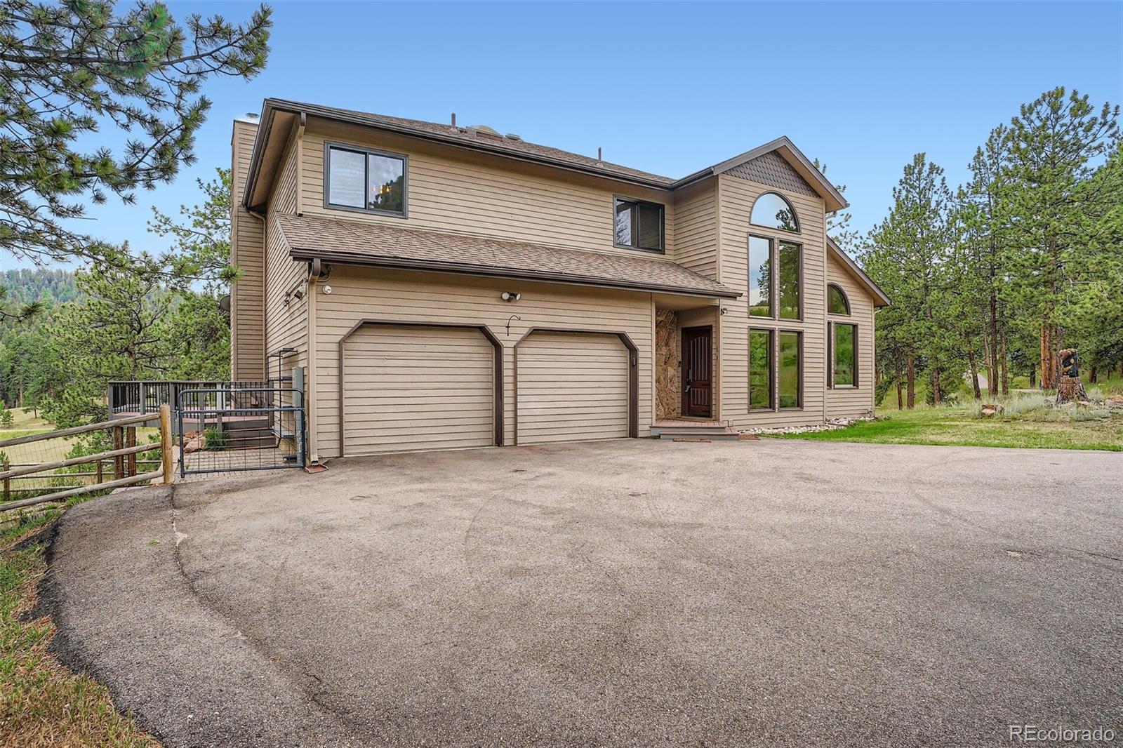 13342 Douglass Ranch Drive Pine, CO 80470 - Photo 5 of 31 a front view of a house with a yard and garage