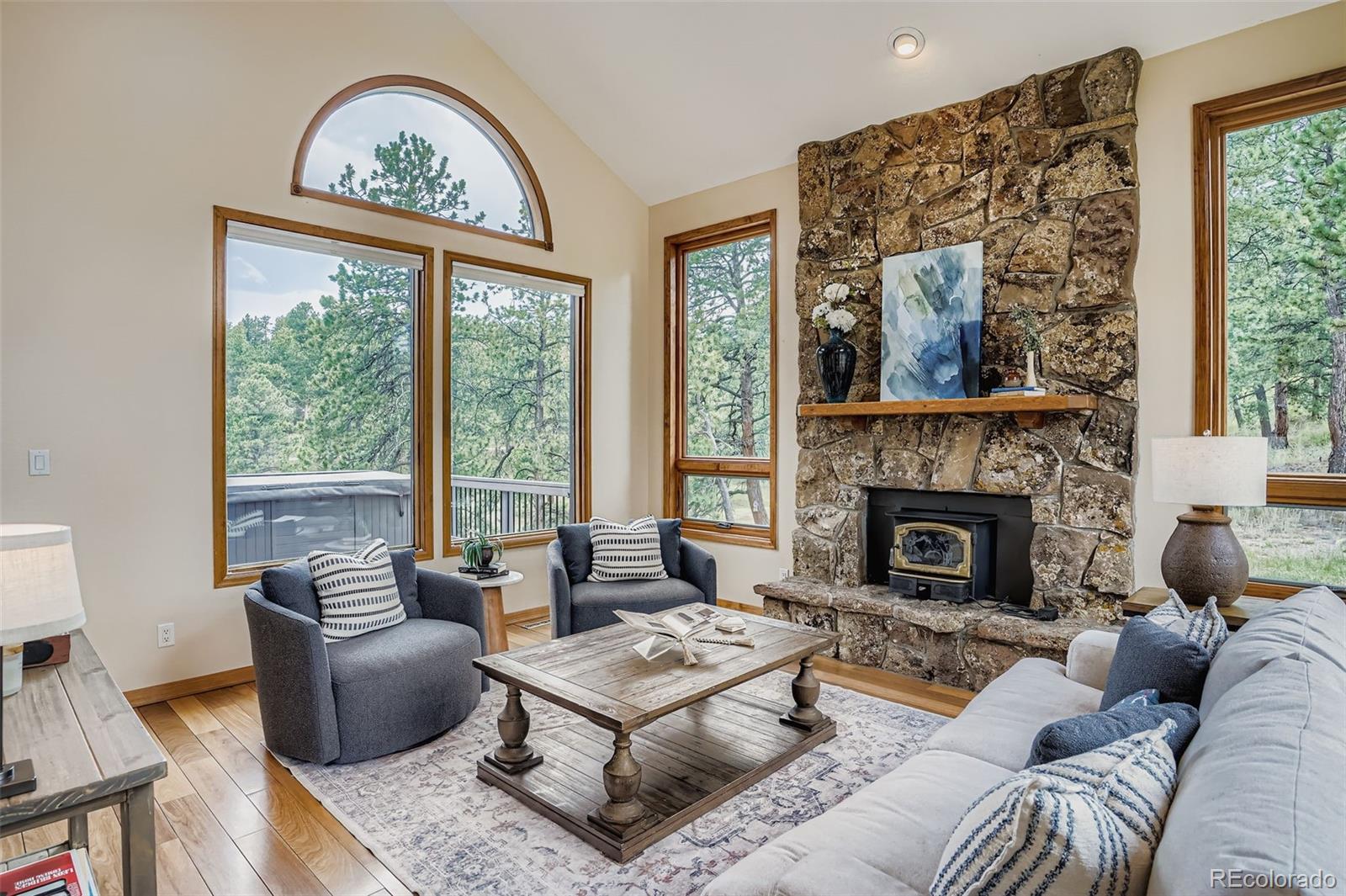 13342 Douglass Ranch Drive Pine, CO 80470 - Photo 6 of 31 a living room with furniture a large window and a fireplace
