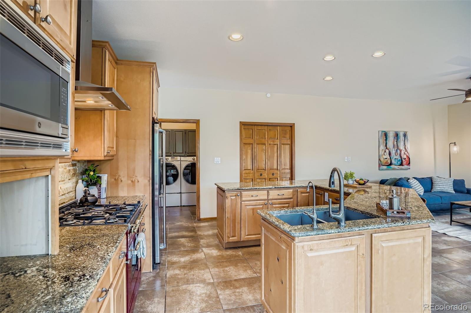 13342 Douglass Ranch Drive Pine, CO 80470 - Photo 10 of 31 a kitchen that has a lot of cabinets a sink and a wooden floor