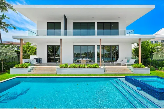 a view of pool with lawn chairs and large trees