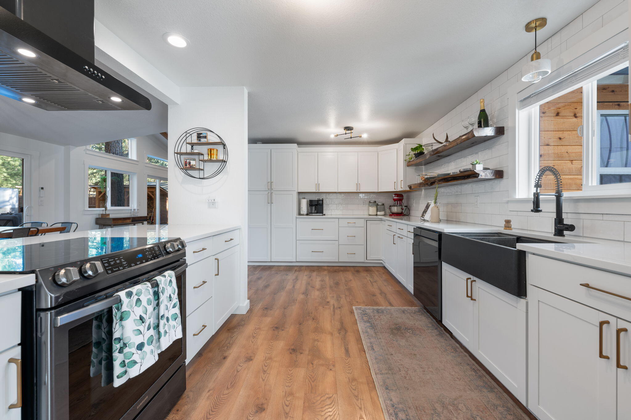 60072 Cinder Butte Road Bend, OR 97702 - Photo 23 of 60 a large kitchen with stainless steel appliances granite countertop a stove a sink dishwasher and cabinets with wooden floor