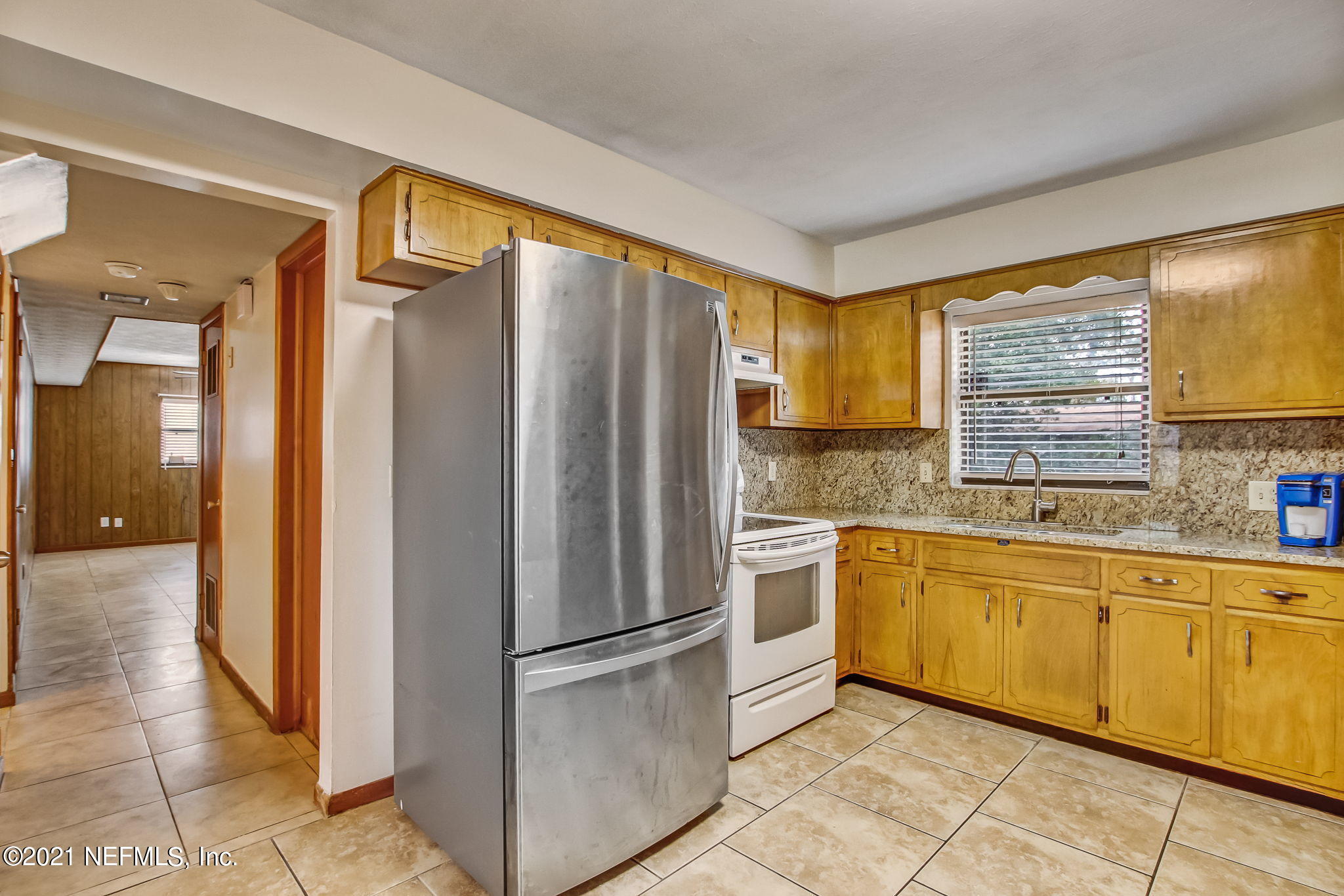 8290 Barracuda Road Jacksonville, FL 32244 - Photo 17 of 41 a kitchen with stainless steel appliances granite countertop a refrigerator and a sink