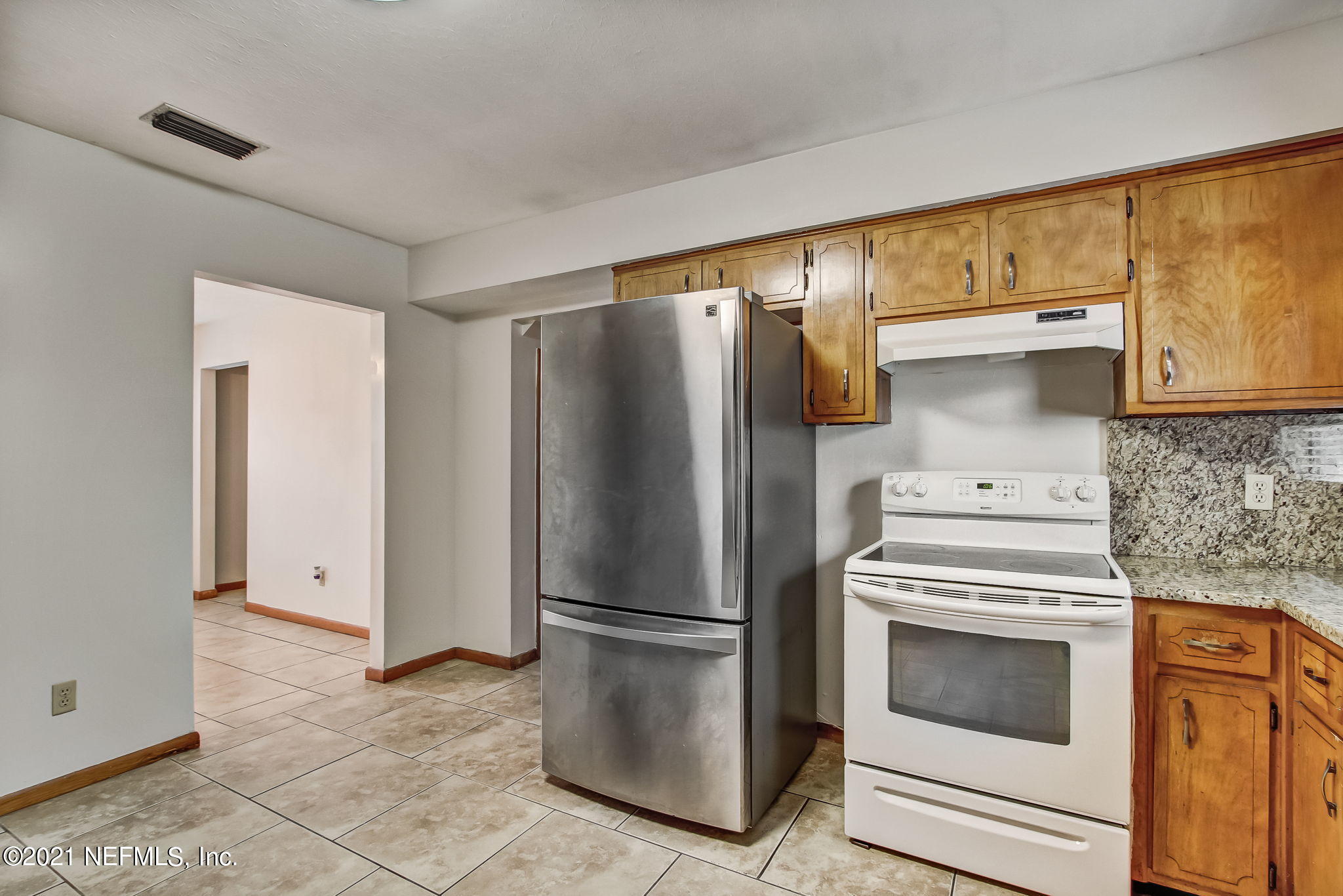 8290 Barracuda Road Jacksonville, FL 32244 - Photo 19 of 41 a kitchen with stainless steel appliances a refrigerator stove and cabinets