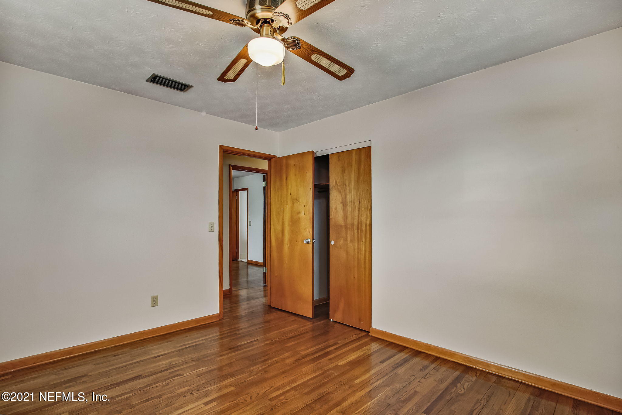 8290 Barracuda Road Jacksonville, FL 32244 - Photo 29 of 41 an empty room with wooden floor fan and windows