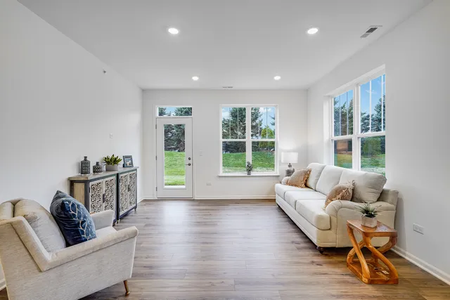 a living room with furniture and a wooden floor