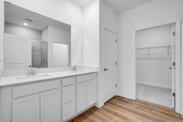 a spacious bathroom with a double vanity sink and mirror