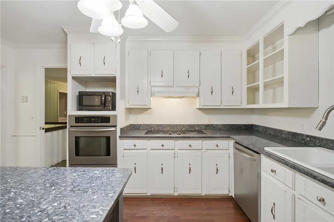 311 Cumberland Way Anderson, SC 29621 - Photo 11 of 44 A well-appointed kitchen features rich hardwood flooring and sleek stainless steel appliances, ready for culinary endeavors.