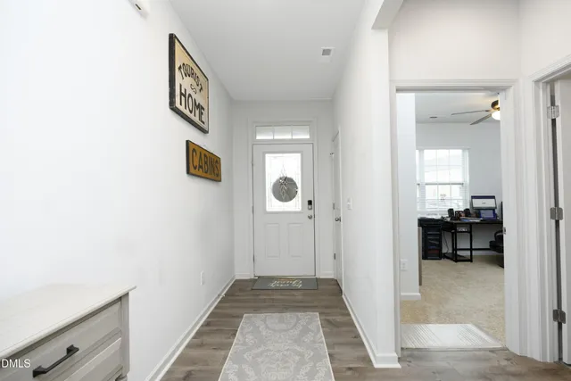 a view of a hallway and a dining room with wooden floor