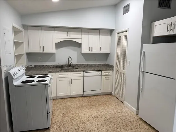 a kitchen with a stove a refrigerator and cabinets