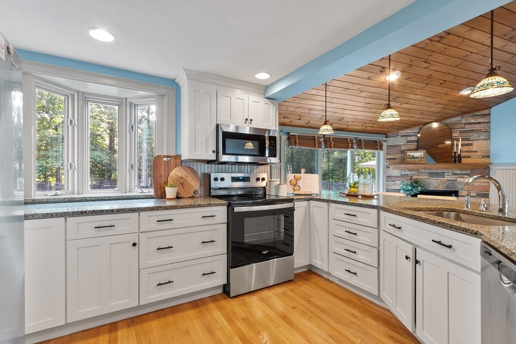 26 Wing Road Lynnfield, MA 01940 - Photo 9 of 39 a kitchen with granite countertop white cabinets a sink a window and stainless steel appliances