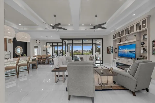 a living room with furniture kitchen view and a large window
