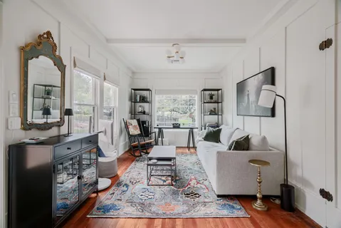 a living room with furniture wooden floor and a chandelier