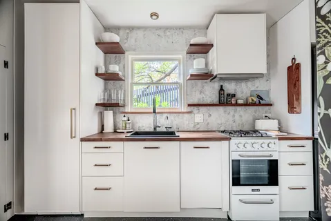 a kitchen with granite countertop a sink stainless steel appliances and cabinets