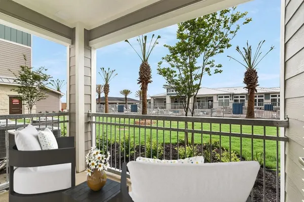 a view of a patio with couches chairs potted plants and a small yard