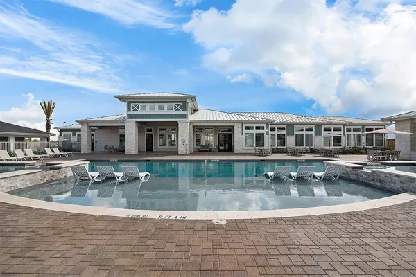 a view of a house with swimming pool and sitting area