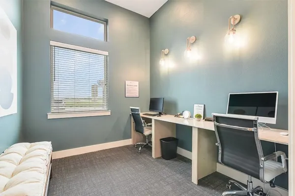 a view of a workspace with furniture and a window