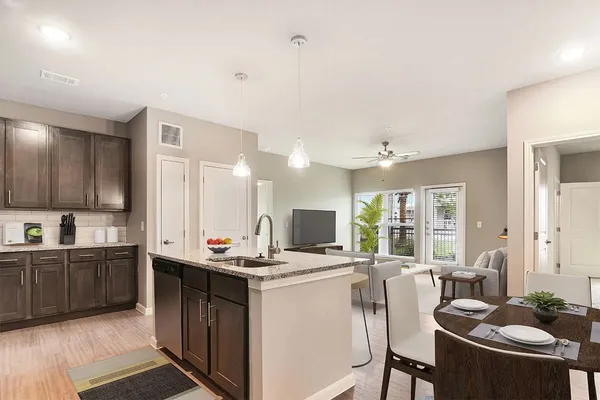 a kitchen with a stove a sink a dining table and chairs