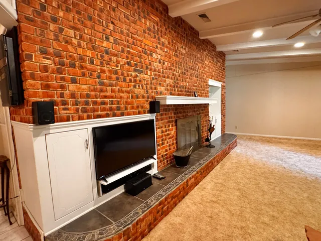 a living room with a flat screen tv on the wall and a stove
